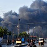 Thick plumes of black smoke rise into the sky after a fire erupted in a factory at Site industrial area