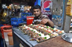 A paan vendor prepares sweet paan with fennel seeds, cardamom and other aromatic ingredients for customers at Lakshmi Chowk.