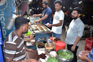 A paan vendor dips betel leaves in water to keep them fresh and clean while preparing paan for customers at Lakshmi Chowk.